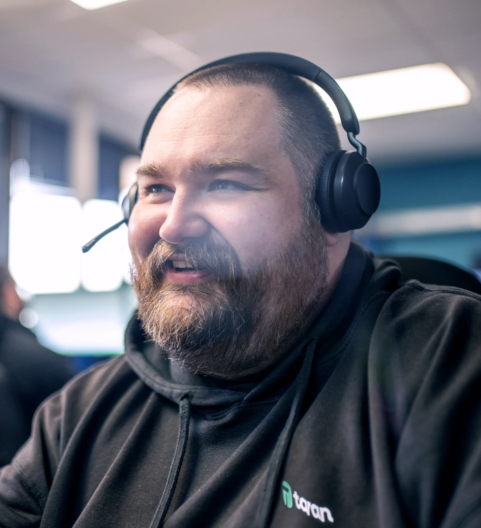 Taran IT support technician wearing a headset while assisting a client from the office.